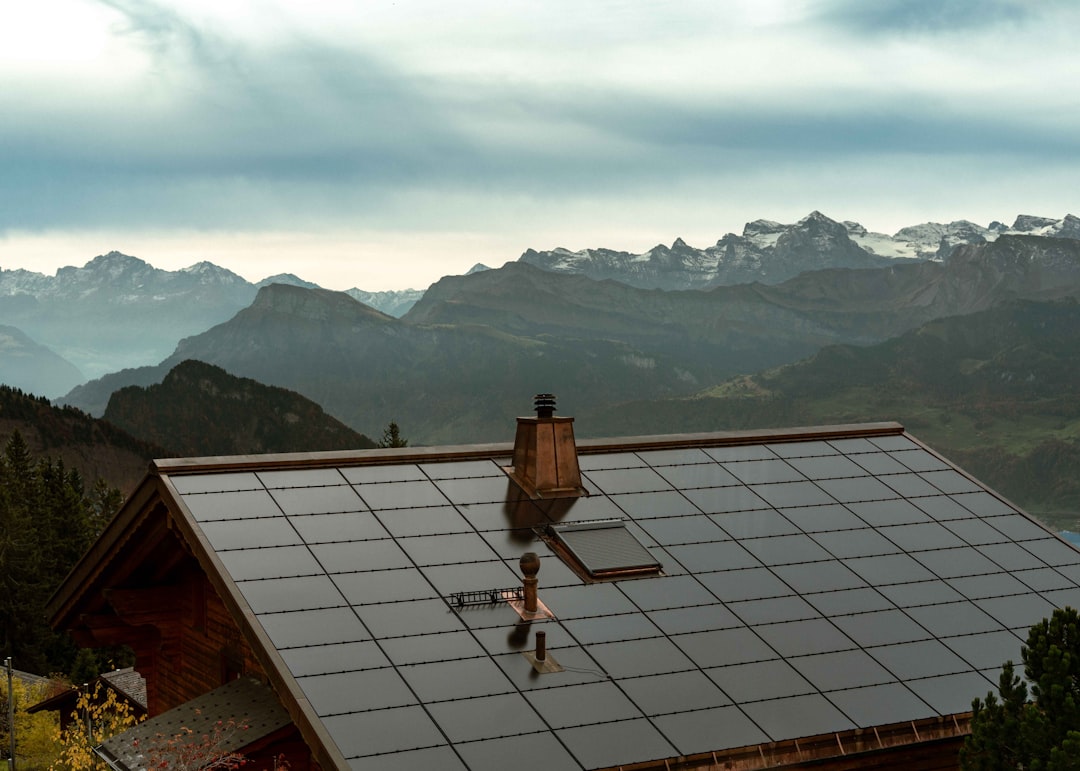 Solar panels cover the roof of a mountain cabin.