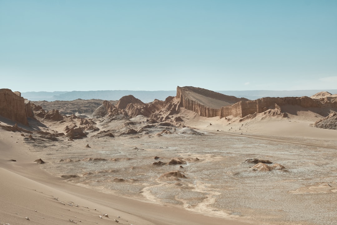 Arid desert landscape with rock formations under a clear sky