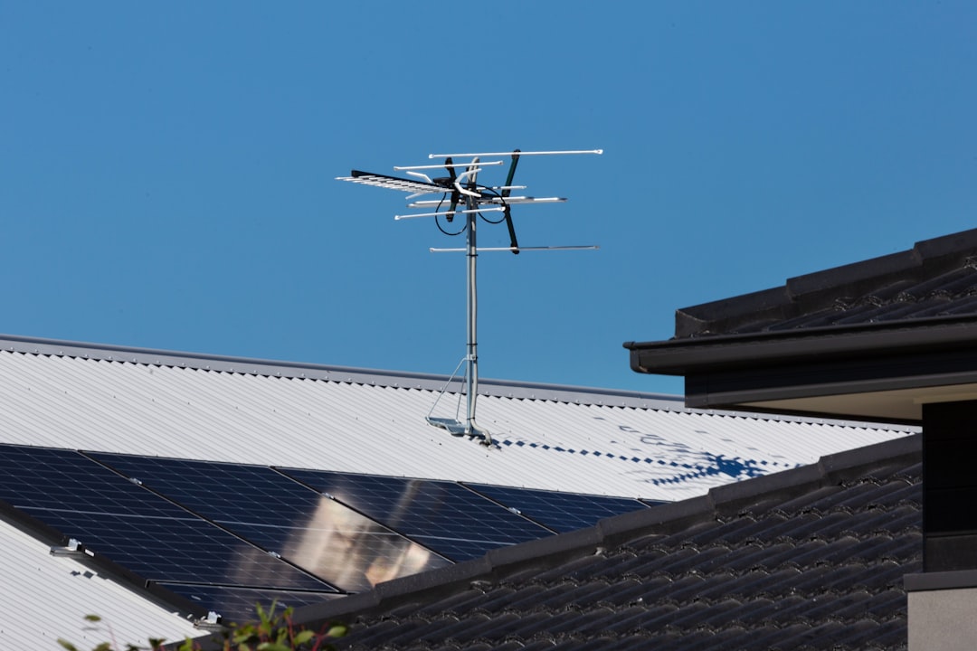 A television antenna stands tall against a clear blue sky.